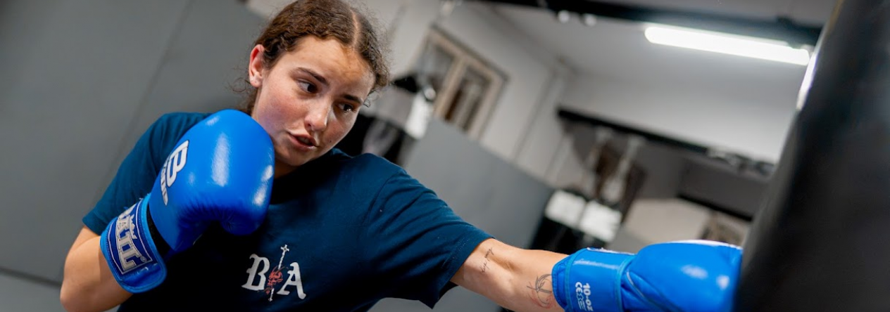 Kateřina Marynets při tréninku boxu s modrými rukavicemi u boxovacího pytle.