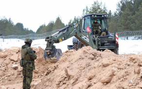 Strojník JCB 4CX při budování ochranných staveb.