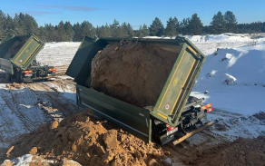 Nákladní vozy Volvo při vykládce materiálu.