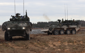 Kanadští ženisté na vozidlech LAV při průjezdu průchodem v drátěném zátarasu.