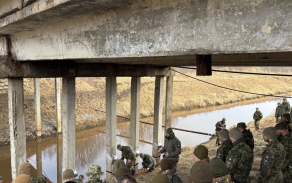 Velitel ženijní čety vysvětluje postup při přípravě mostu k ničení.