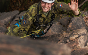 voják, který překonává skálu lezením s horním jištěním
